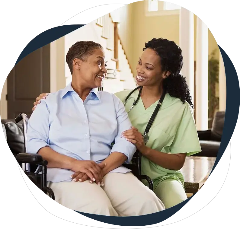 A nurse and an elderly woman smiling for the camera.