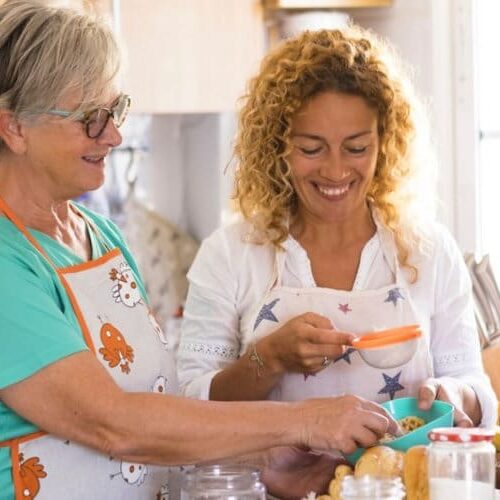 Two women are cooking in a kitchen together.
